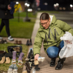 Woman places children’s shoes to voice opposition to mask mandates and potential vaccine requirements.